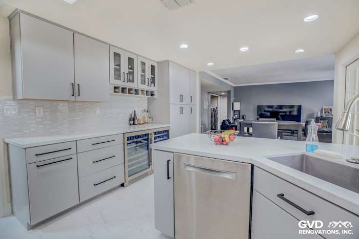 Modern kitchen remodel featuring gray cabinets, quartz countertops, stainless steel appliances, and a wine cooler