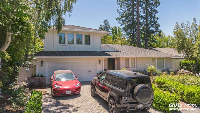 Menlo Park home exterior featuring James Hardie Batten Board siding and new landscape design with two parked vehicles