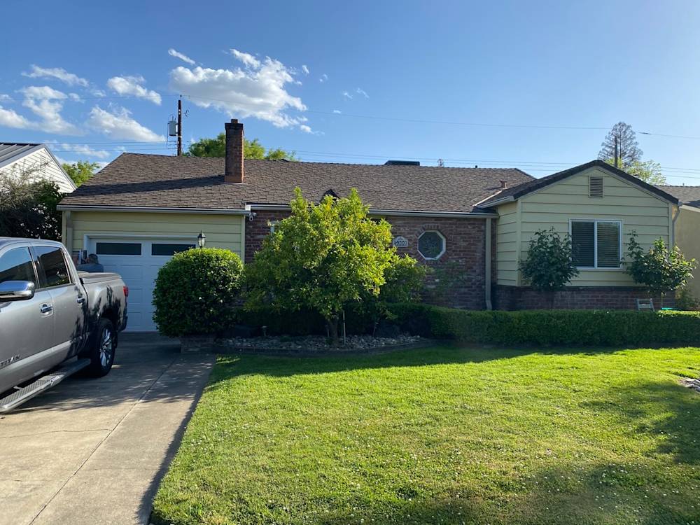 Front view of a suburban Sacramento home with a lush lawn and brick facade