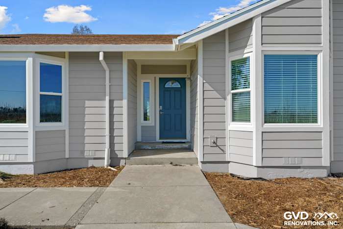 Front exterior of home featuring Pearl Gray James Hardie siding, Arctic White trim, and new Anlin windows in Galt, CA