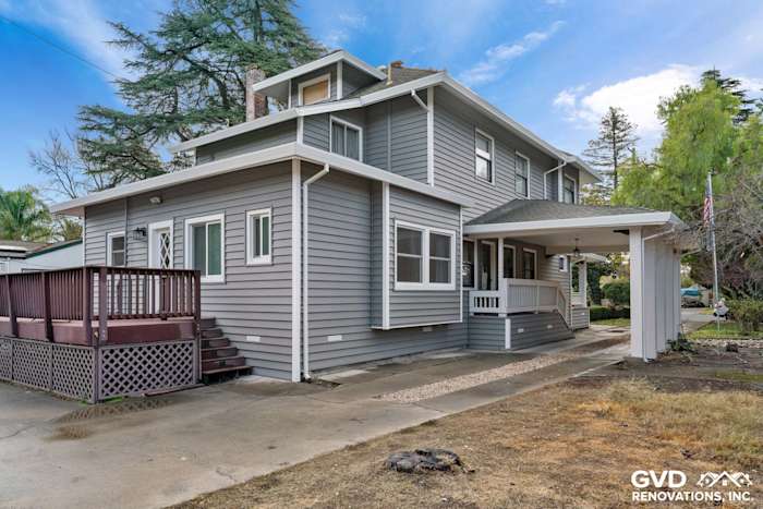 Gray vinyl siding renovation on a two-story home with a porch and wooden deck in Dixon, CA