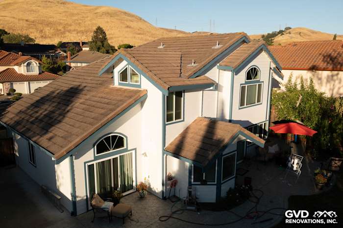 Charming home exterior featuring Arctic White James Hardie siding and new windows, surrounded by a landscaped yard