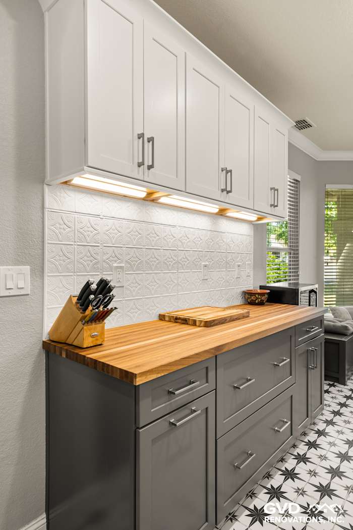 Sleek kitchen remodel with gray cabinetry, wood countertop, and textured white backsplash in Folsom, CA