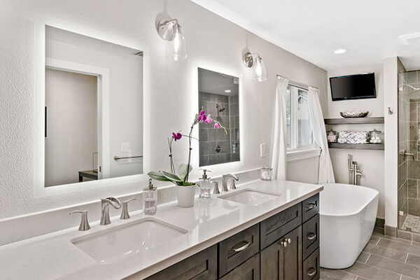 Luxurious master bathroom featuring dark wood cabinetry, modern fixtures, and a sleek freestanding tub