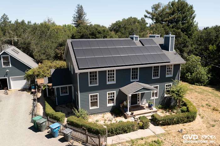 Two-story home featuring new Evening Blue James Hardie lap siding with Arctic White trim and solar panels