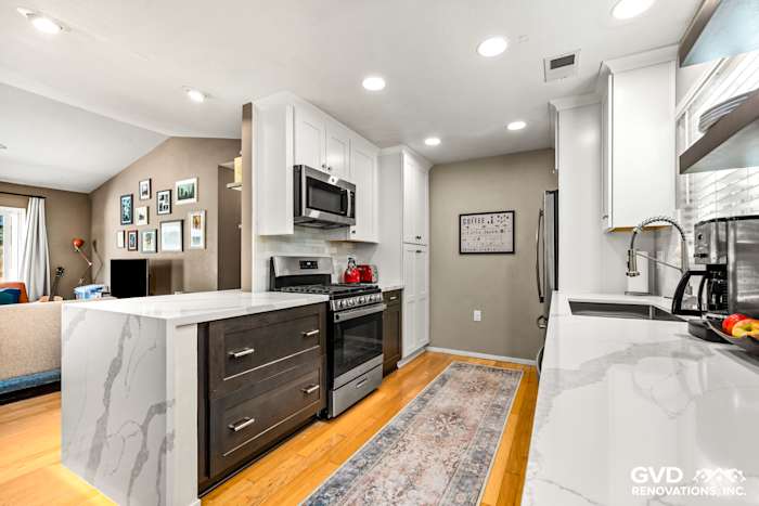 Modern kitchen with white shaker cabinets, quartz countertops, stainless steel appliances, and hardwood flooring in Davis