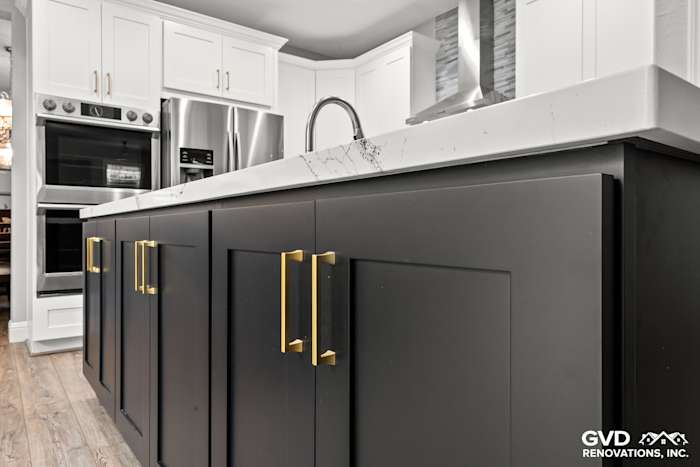 Modern kitchen featuring black custom cabinets with gold handles and Cambria countertop in Roseville, CA