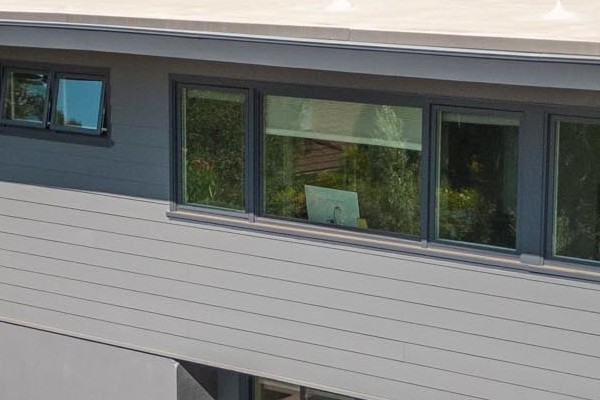 Modern home exterior featuring Night Gray James Hardie Plank Lap Siding in San Rafael, CA, surrounded by lush greenery