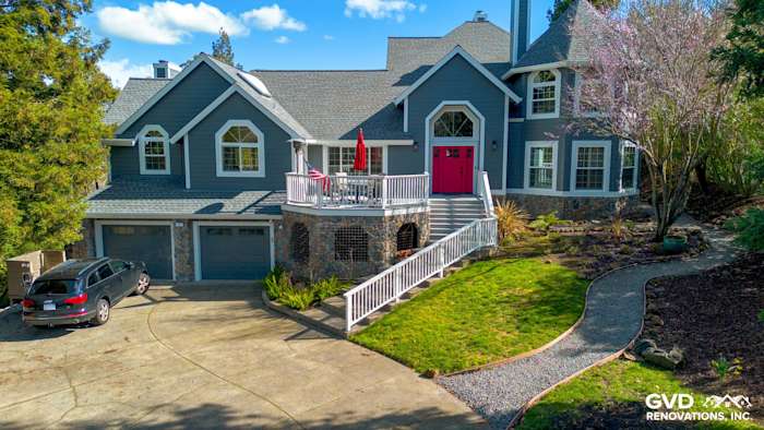Home exterior in Petaluma featuring Night Gray James Hardie siding, Arctic White trim, and a vibrant red door