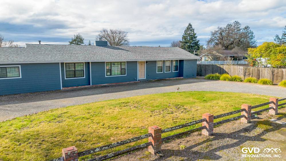 Sonoma home with new James Hardie Evening Blue siding and Arctic White trim, grassy front yard, and gravel driveway
