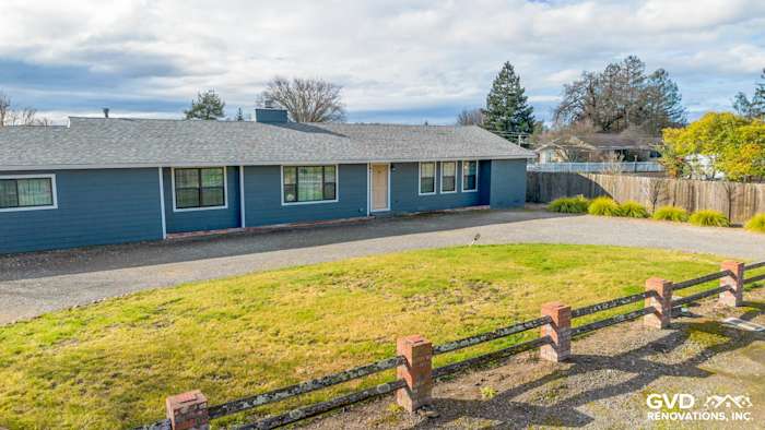Sonoma home with new James Hardie Evening Blue siding and Arctic White trim, grassy front yard, and gravel driveway