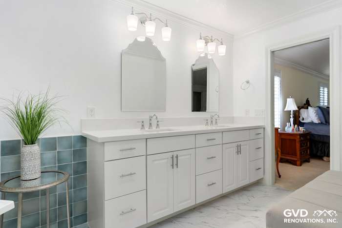 Bright bathroom with dual sinks, white cabinetry, and blue tiled accent wall in Fair Oaks