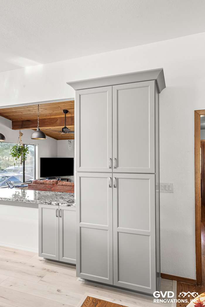 Modern kitchen remodel in Greenwood featuring gray cabinets and granite countertops with open shelving above
