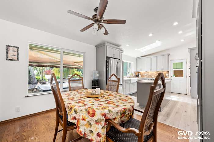 Bright kitchen with modern cabinetry, a floral dining table, and large windows for natural light
