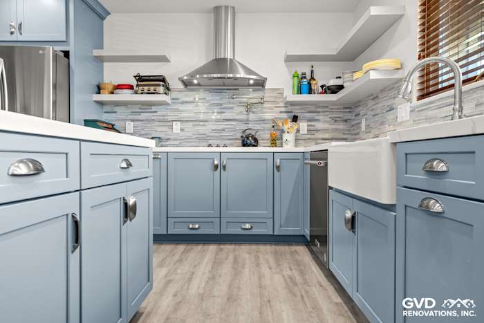 Modern kitchen with blue Waypoint cabinets, MSI Calacatta Ultra countertops, and Misty Fjord backsplash in Elk Grove
