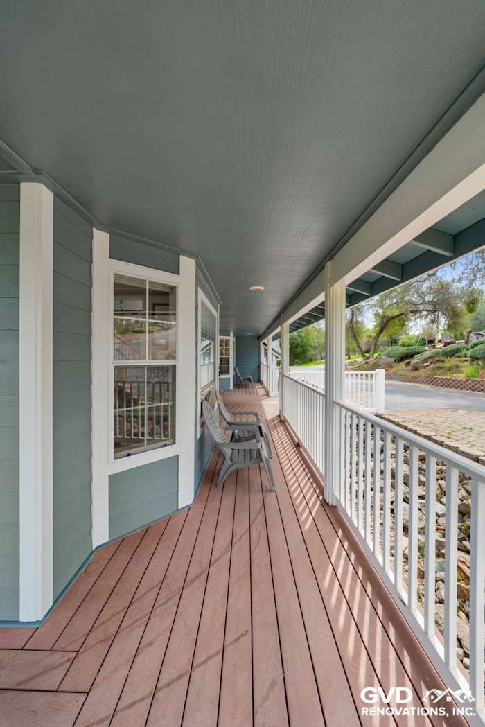 Newly installed James Hardie siding in blue on home exterior, with a spacious porch and composite decking