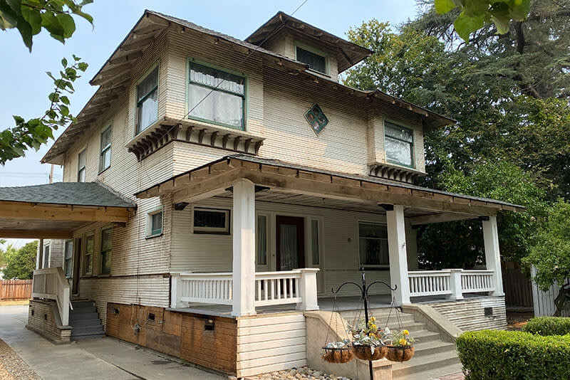Worn wooden siding with peeling paint and outdated architectural details