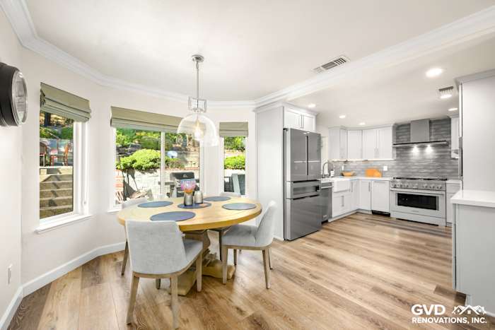 Bright kitchen remodel featuring modern gray cabinets, stainless steel appliances, and a circular dining table