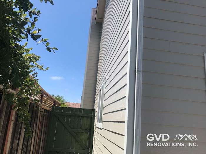 Arctic White James Hardie siding on home exterior, showcasing smooth finish and green gate in Concord, CA