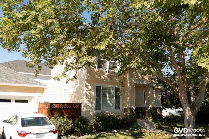 Home exterior featuring Prodigy insulated vinyl siding in soft yellow, surrounded by leafy trees in Petaluma