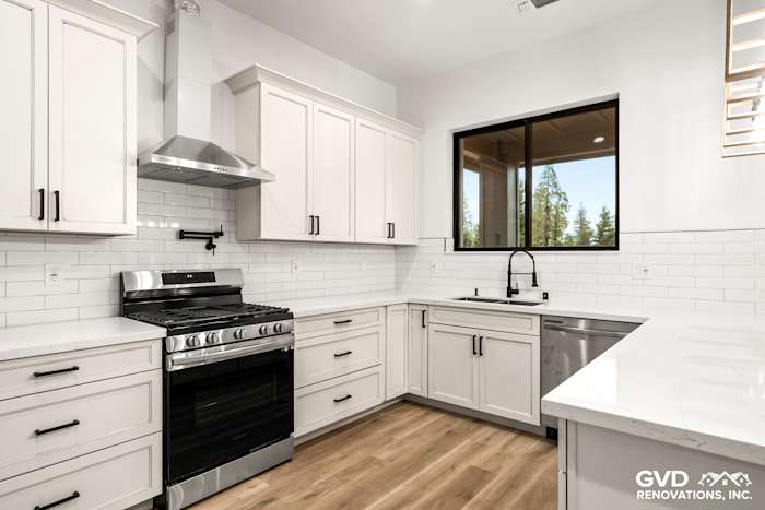 Modern kitchen with white shaker cabinets, stainless steel appliances, and quartz countertops in new construction home