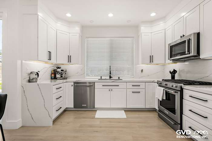 Bright Antelope kitchen with quartz countertops, custom white cabinets, stainless steel appliances, and a sleek backsplash