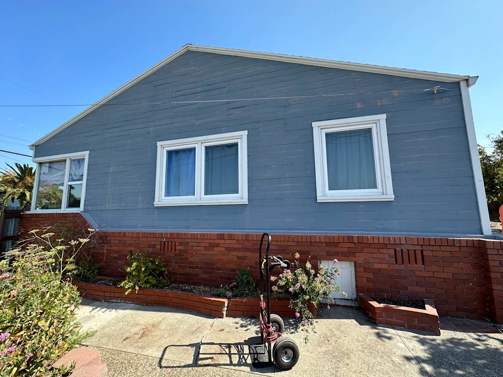 Exterior view of a blue house with red brick features in Northern California