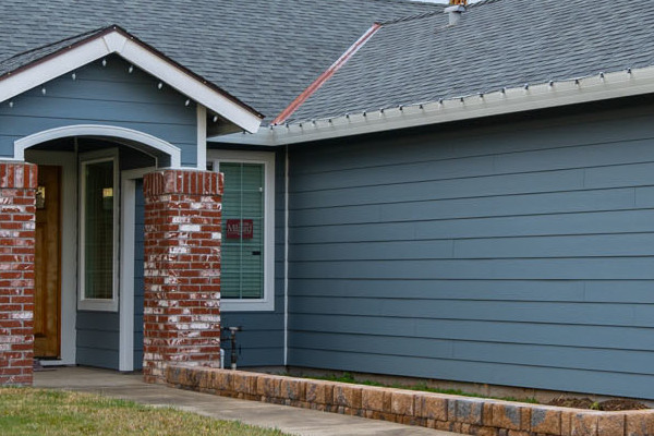 Home exterior featuring Boothbay Blue James Hardie siding, Arctic White trim, and new brick accents in Sacramento