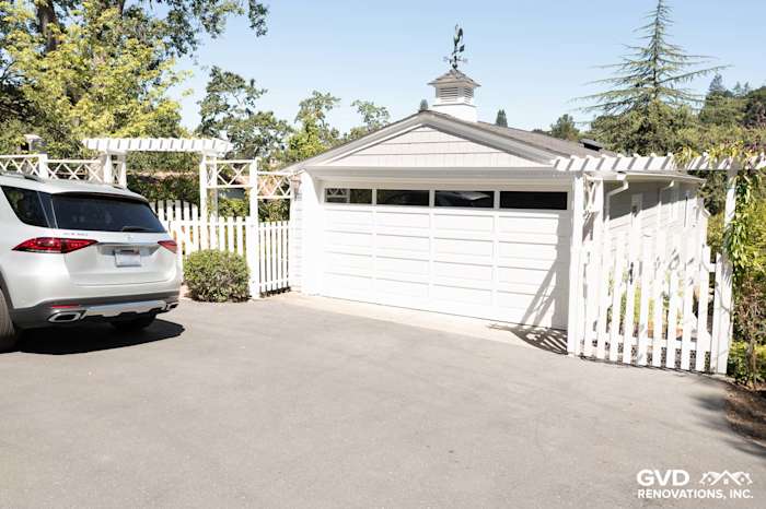 Home exterior featuring James Hardie Shingle Siding in Pearl Gray, garage door, and white picket fence in Orinda