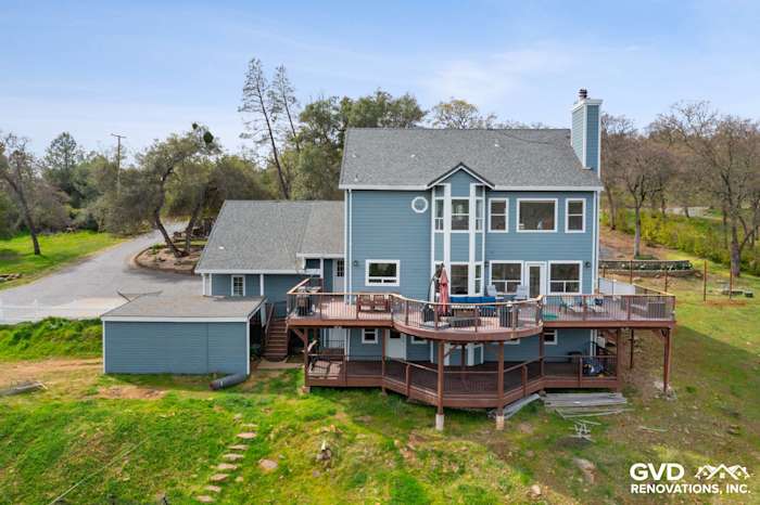 Transformative home exterior featuring new blue James Hardie siding and a wooden deck in Shingle Springs