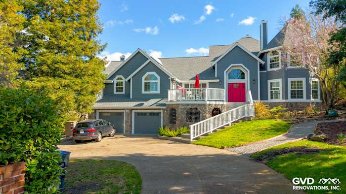 Home exterior in Petaluma, featuring Night Gray James Hardie siding, Arctic White trim, and a vibrant red door