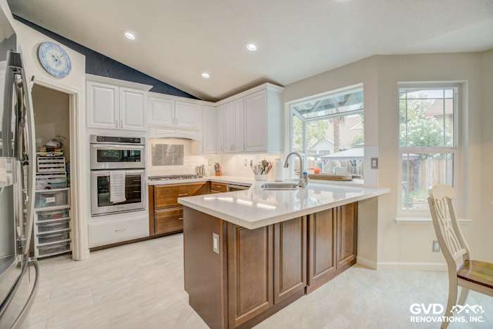 Modern kitchen remodel in Elk Grove featuring white cabinetry, quartz island countertop, and stainless steel appliances