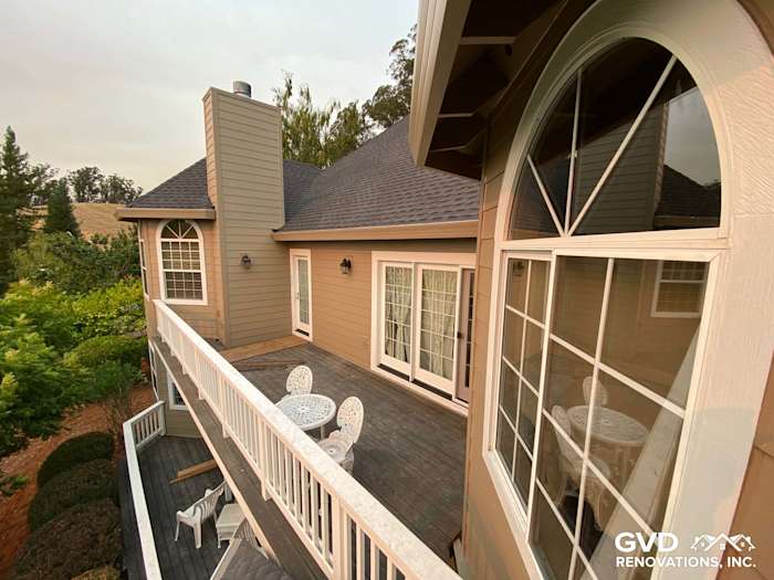Elevated view of a home exterior featuring Khaki Brown James Hardie siding and a deck with white furniture