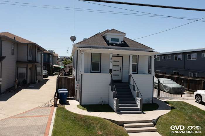 Two-story home with Arctic White James Hardie siding and trim, modern front steps, and a well-maintained yard in San Leandro