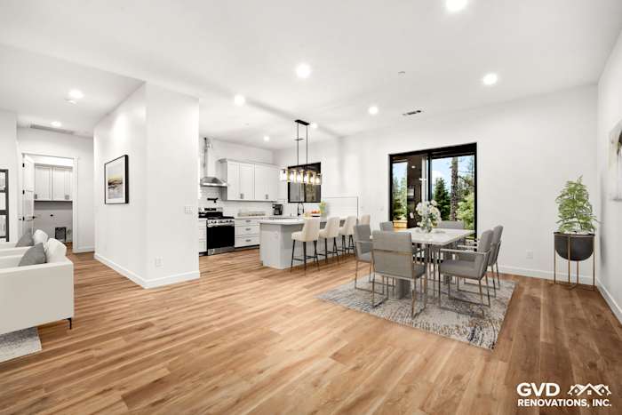Spacious modern kitchen and dining area with Waypoint cabinetry and hardwood flooring in Paradise, CA home