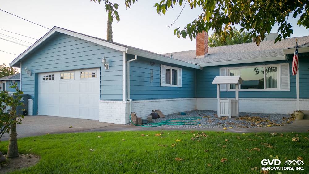 Home exterior featuring new Alside Prodigy vinyl siding in blue, complemented by a white brick foundation and garage