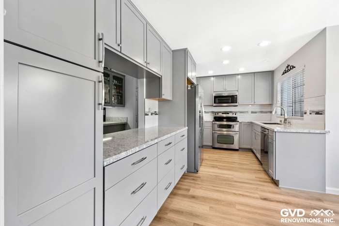 Modern Carmichael kitchen remodel featuring gray shaker cabinets, quartz countertops, and stainless steel appliances