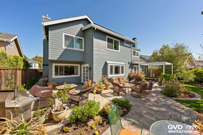 Boothbay Blue HardiePlank siding and Arctic White trim adorn a modern home exterior in Foster City, featuring a patio garden