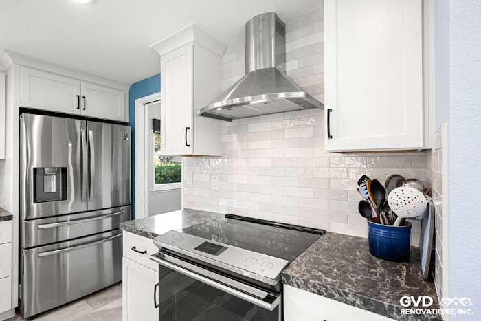 Modern Fair Oaks kitchen featuring stainless steel appliances, white cabinetry, and a sleek gray countertop with decorative