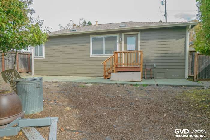 updated home exterior featuring Prodigy Solid Core Siding in green, new front steps, and patio area