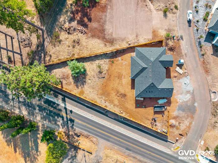Aerial view of a new construction home in Paradise, CA, surrounded by cleared land and trees