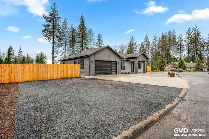 Modern home exterior in Paradise with James Hardie siding, black Milgard windows, and a gravel driveway