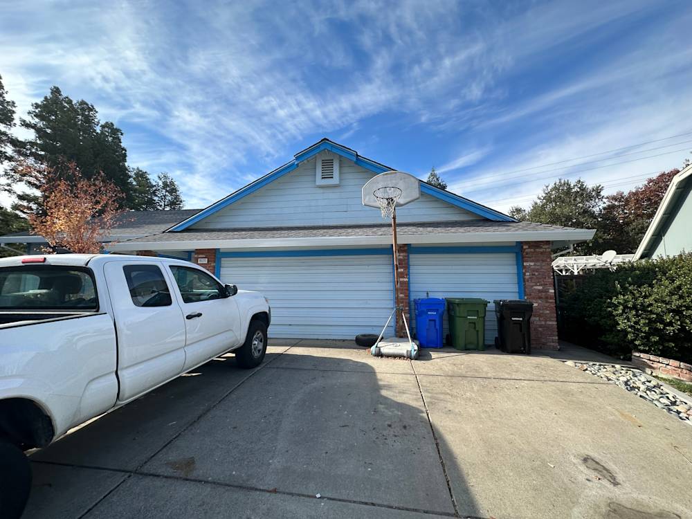 Front view of a suburban Sacramento home with blue accents and a concrete driveway