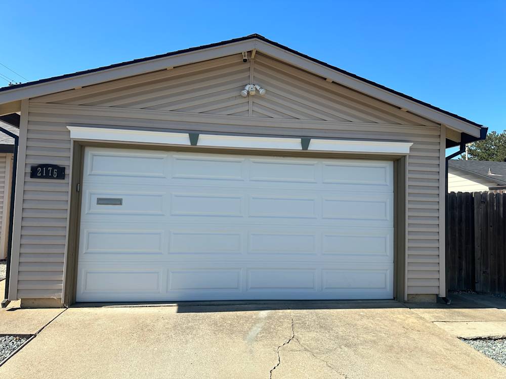 Single-story garage with beige siding and a white door in Sacramento, California