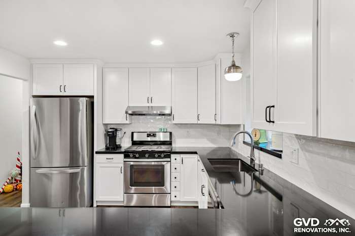 Modern kitchen remodel featuring white Shaker cabinets, stainless steel appliances, and black countertops in Loomis, CA
