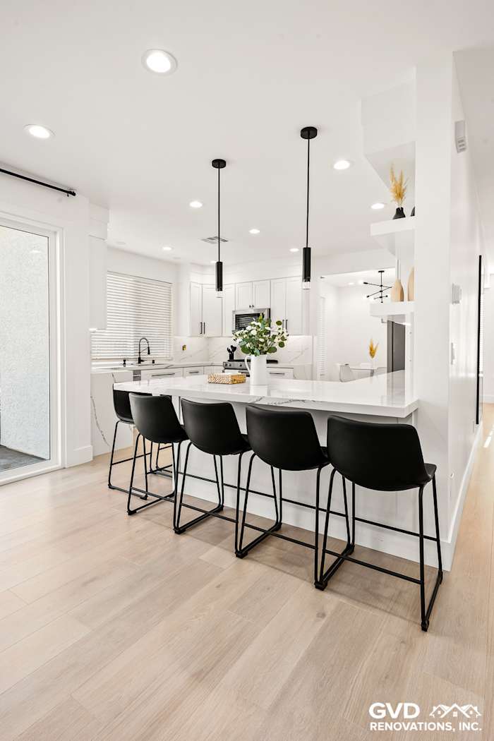 Modern kitchen remodel in Antelope with quartz countertops, black bar stools, and custom cabinetry. Bright and elegant design