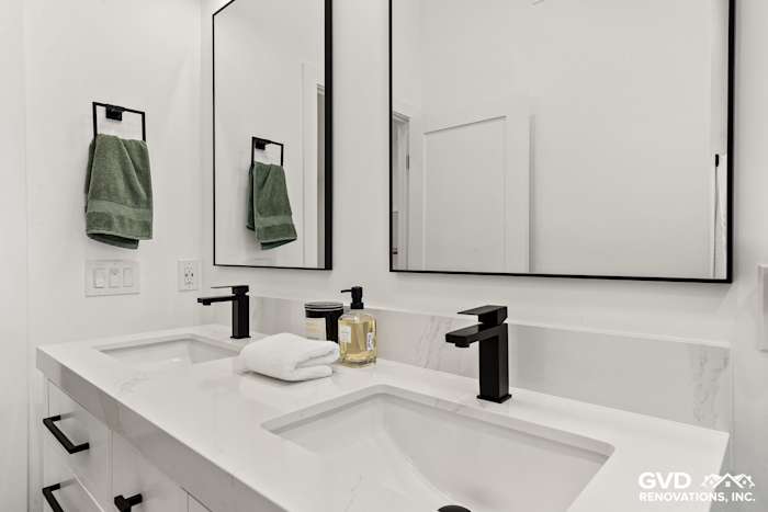 Modern bathroom remodel with dual vanity, quartz countertop, black fixtures, and sleek mirrors in Antelope, CA