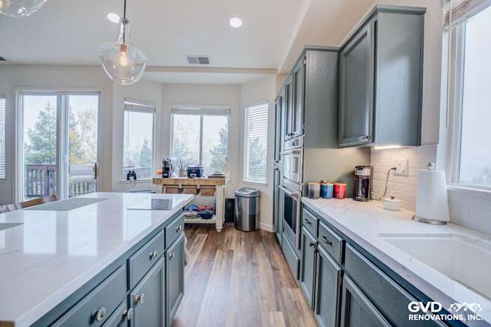 Stylish kitchen with gray cabinets, white quartz countertops, and large windows in El Dorado Hills
