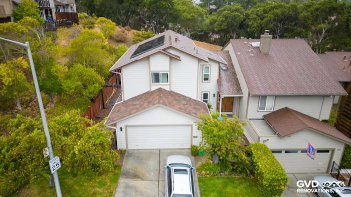 Home exterior in San Mateo featuring James Hardie Cobble Stone siding and Khaki Brown trim, surrounded by greenery