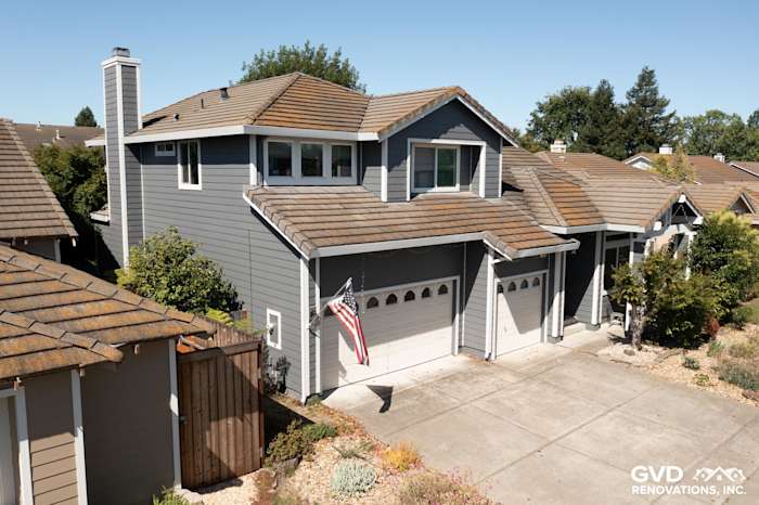 Exterior of Petaluma home showcasing James Hardie Night Grey siding, Arctic White trim, and new garage doors